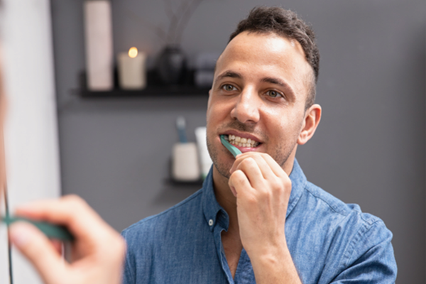 Man borstar tänderna med Jordan Clinic-tandborste
