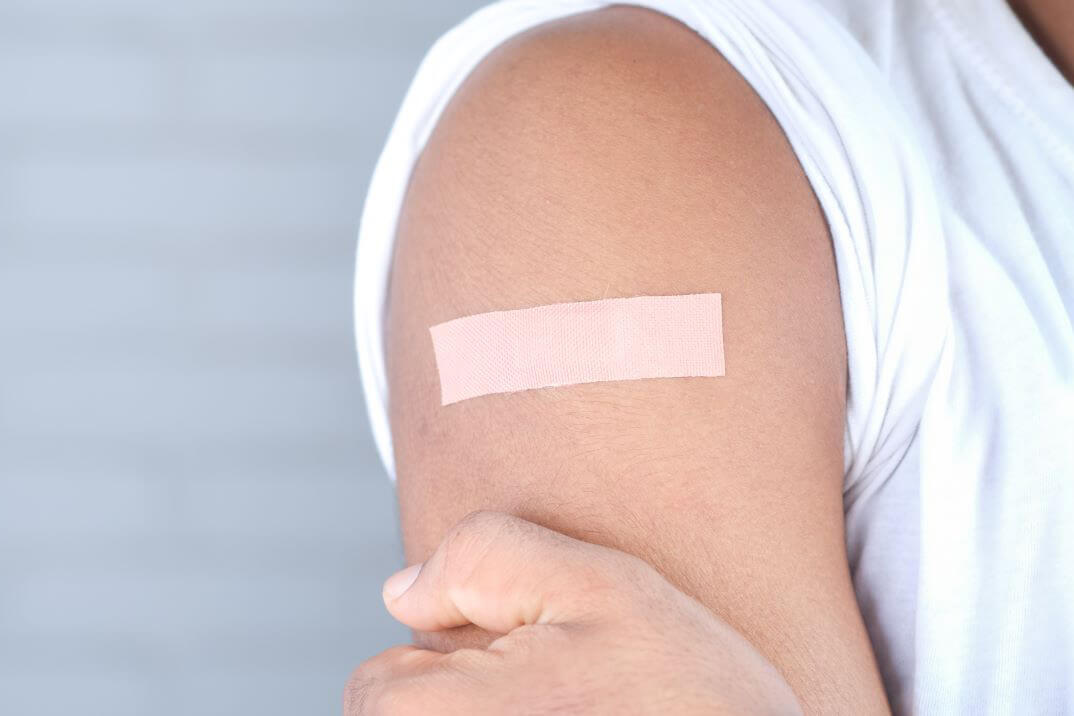 Plåster på en överarm efter vaccinering