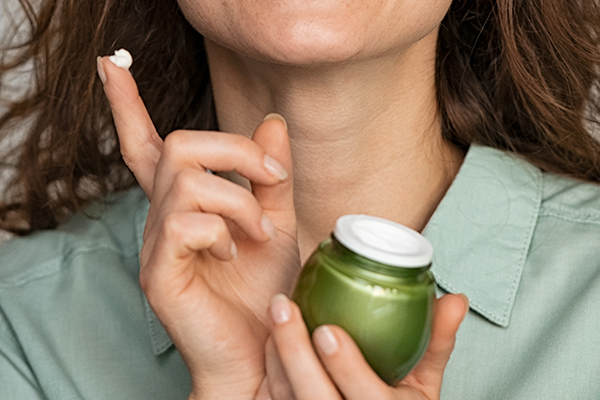 Kvinna som håller upp ansiktskräm utan cykliska silikoner