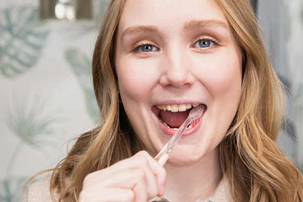 Kvinna borstar tänderna med Jordan Clinic-tandborste