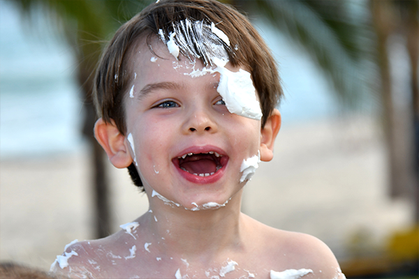 Barn som fått solskydd i form av mousse i ansiktet