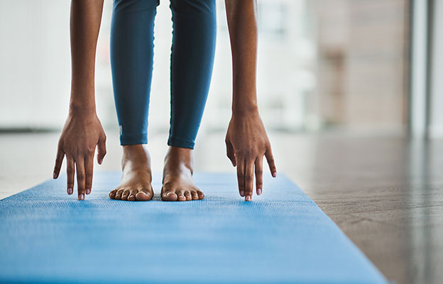 Fötter som står på en yogamatta