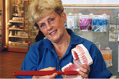 Kvinna visar hur man borstar tänderna med gnuggmetoden