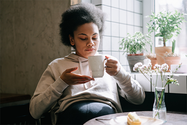 Gravid kvinna sitter på café och dricker te