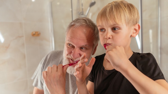 pappa och barn borstar tänderna